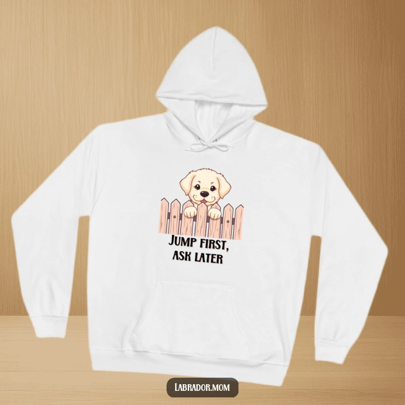 Funny Labrador pup peeking over a fence with an eager expression, printed on a warm hoodie, perfect for gifting.
